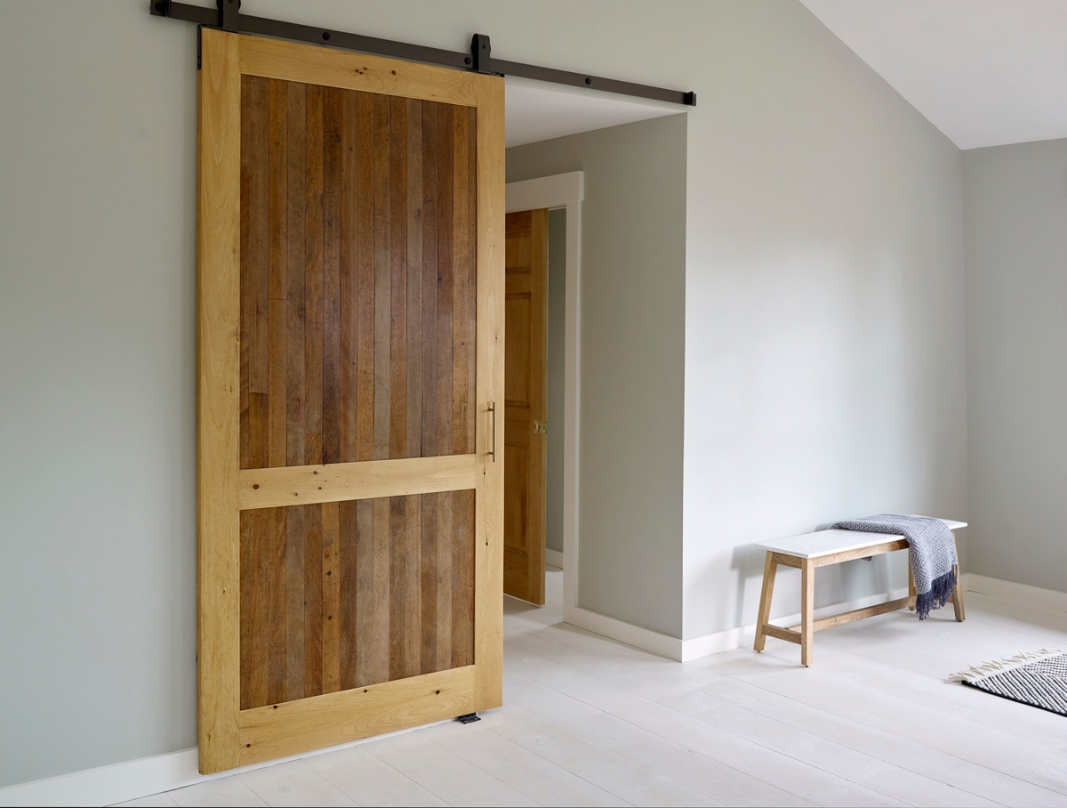 Custom barn door built from reclaimed shelves from a family workshop