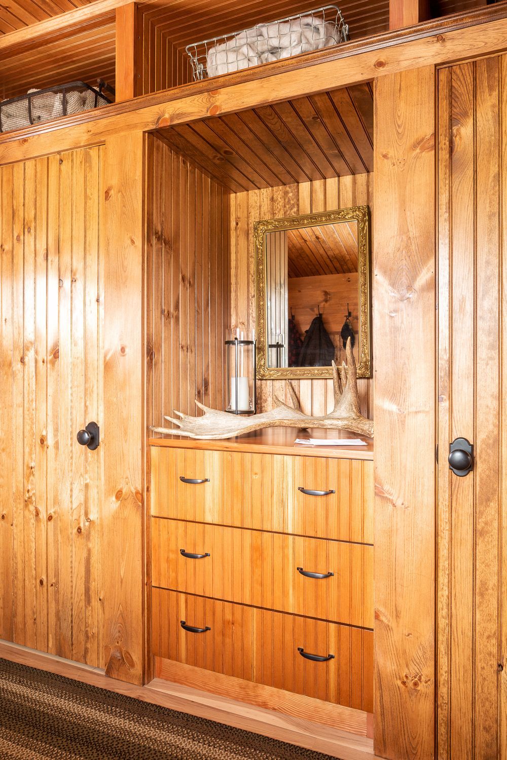 Built-in closet with storage cubbies above built-in drawers with countertop at Camp Ridlon
