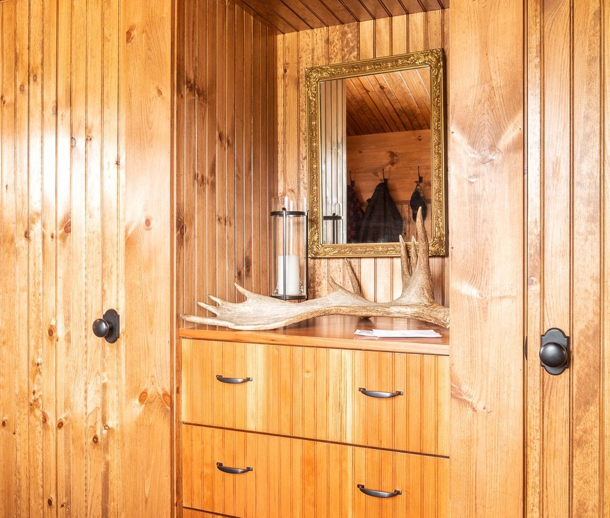 Built-in closet with storage cubbies above built-in drawers with countertop (Camp Ridlon)