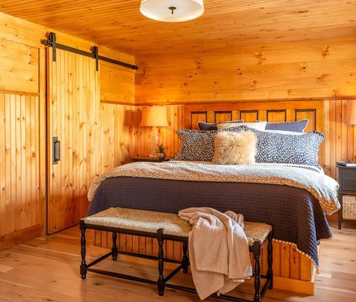 Custom-built bed with a reclaimed five-panel door headboard and built-in storage drawers underneath. (Camp Ridlon)